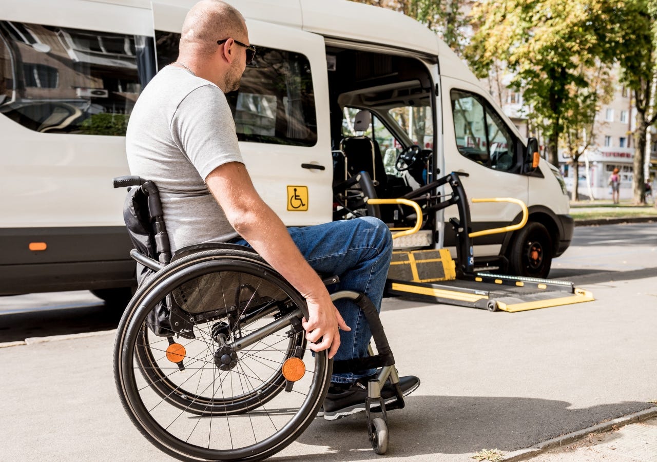 man in wheelchair outside of a wheelchair accessible van