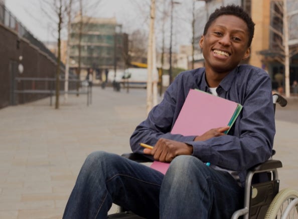 man smiling in wheelchair outside