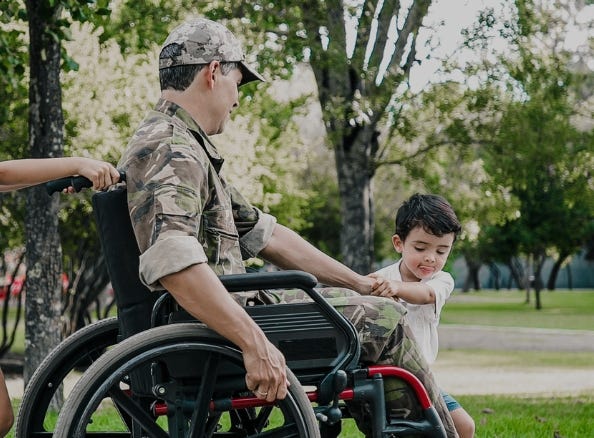 veteran in wheelchair with children outdoors